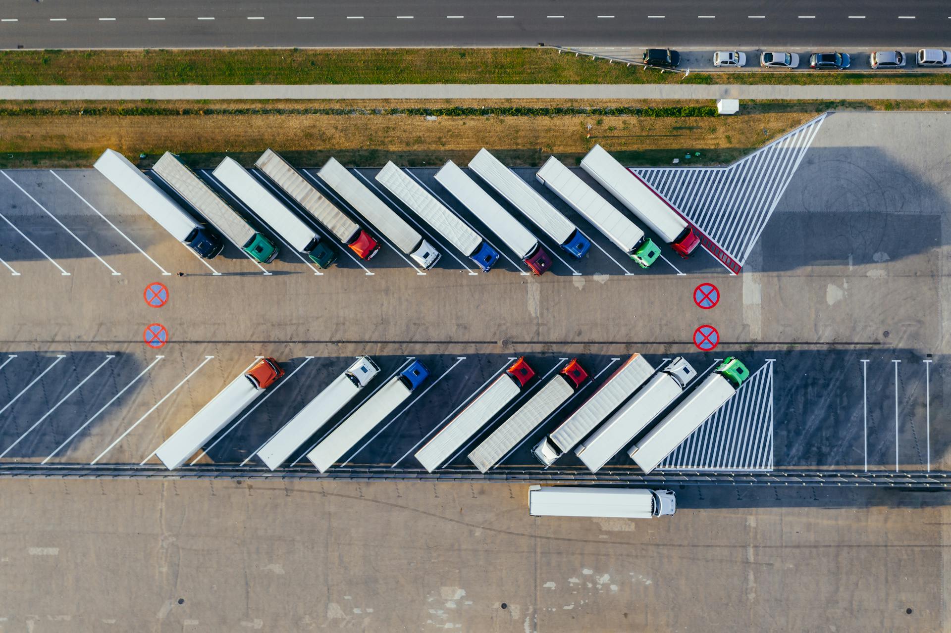 Aerial view of semi-trucks parked in numbered staging bays